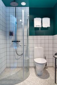 a bathroom with a toilet and a glass shower at Grundéns Hotell in Grundsund +80 photos