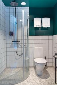 a bathroom with a toilet and a glass shower at Grundéns Hotell in Grundsund