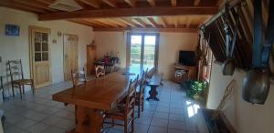 une grande salle à manger avec une table et des chaises en bois dans l'établissement La ferme du Bouton d'Or, à Vendranges