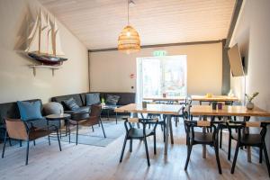 a room with tables and chairs and a couch at Grundéns Hotell in Grundsund