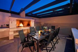 a dining room with a table and a fireplace at Sun Spalato Hills in Split