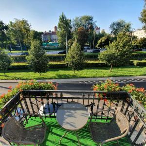 a table and chairs in a park with flowers at Bagel Residence Old Town in Kraków