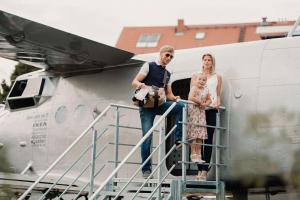 a man and a woman and a child standing on a plane at Antonov im Garten – Flugzeug-Ferienwohnung in Altendorf