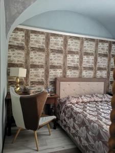 a bedroom with a bed and a desk and a chair at Hotel Sangiuliano 132 centro storico Catania in Catania