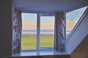 uma janela num quarto com vista para o oceano em Beachcombers em Dumfries