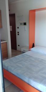 uma cama com cabeceira laranja num quarto em Elena Club Resort em Silvi Marina