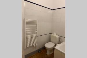 a white bathroom with a toilet and a sink at Appartement entre Paris et CDG in Écouen