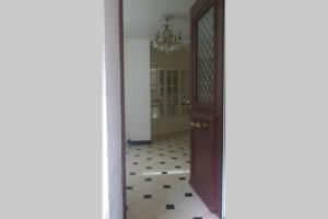 a hallway with a wooden door and a tiled floor at Appartement entre Paris et CDG in Écouen