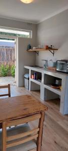 uma cozinha com uma mesa de madeira e uma bancada em Kortrijk Paarl Self Catering em Paarl