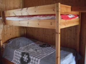two bunk beds in a wooden room with a bed at Chalet montagne 11 p Grand Massif 100 m télécabine in Morillon
