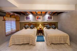 a bedroom with three beds in a room at La Casona Colorada San Felipe del Agua in Oaxaca City