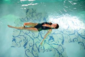un hombre nadando en una piscina en el agua en Torre Del Nera Albergo diffuso & Spa, en Scheggino