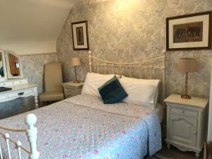 a bedroom with a bed with a blue comforter at Acorn Guest House in Hull in Hull