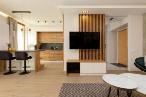 salon z telewizorem i kuchnią w obiekcie Apartment Forest Club Kabaty by Renters Prestige w Warszawie