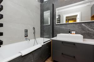 W łazience znajduje się umywalka, wanna i lustro. w obiekcie Apartment Forest Club Kabaty by Renters Prestige w Warszawie