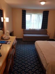 a hotel room with a bed and a window at Travel Plaza Hotel in Desborough