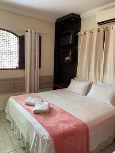 a bedroom with a large bed with two towels on it at Pousada Cabo Branco in João Pessoa