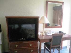 a living room with a tv and a dresser at Travelodge by Wyndham Drumheller AB in Drumheller