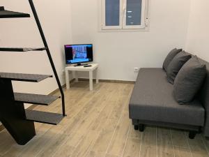 sala de estar con sofá y TV en Piso céntrico y funcional, en Madrid