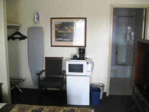 a kitchen with a microwave, refrigerator, and sink at Travelodge by Wyndham Drumheller AB in Drumheller