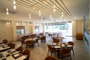 un ristorante con tavoli e sedie in una stanza di Hotel Silver Oak ad Aurangabad