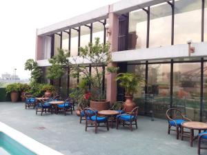 eine Außenterrasse mit Stühlen, Tischen und Fenstern in der Unterkunft Hotel Stella Maris in Mexiko-Stadt