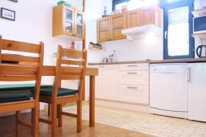 cocina con armarios blancos, mesa y sillas en Apartment Alpe, en Kranjska Gora
