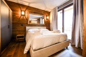a bedroom with a bed and a large window at Chalet Everest - Luxury Apartments in Prato Nevoso