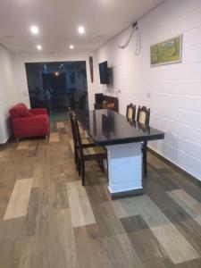 a room with a table and a red couch at Balli Suítes in Ilha Comprida