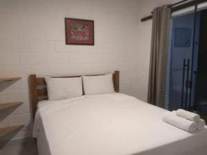 a bed with white sheets and pillows in a room at Balli Suítes in Ilha Comprida +12 photos