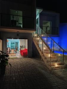 a house with a staircase leading to a living room at Balli Suítes in Ilha Comprida