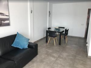 a living room with a black couch and a table at Villa Maria in Playa Blanca
