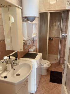 a bathroom with a white sink and a toilet at Apartment Tomasović Old Town in Dubrovnik