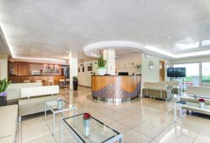 eine Lobby mit Sofas und Tischen in einem Gebäude in der Unterkunft Hotel Du Lac in Rimini