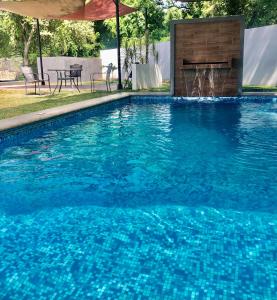 - une piscine avec une fontaine au milieu dans l'établissement EXCELENTE CASA EN PRIVADA ALBERCA- GYM-JARDÍN- Asador, à Ciudad Valles