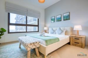 Un dormitorio con una cama grande y una ventana en Exquisite 2BR in Golf Views, Emaar South by Deluxe Holiday Homes en Dubái
