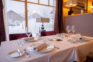 einen Tisch mit einem weißen Tischtuch, Tellern und Gläsern in der Unterkunft Chalet RoyAlp Hôtel & Spa in Villars-sur-Ollon