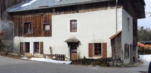 an old white house with a wooden at Chalet montagne 11 p Grand Massif 100 m télécabine in Morillon