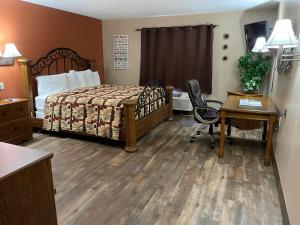 BloomfieldにあるSouthfork Motelのベッド、デスク、デスクが備わる客室です。