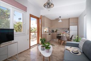 salon z niebieską kanapą i kuchnią w obiekcie Casa EleMar Villa with Private Yard w mieście Hersonissos