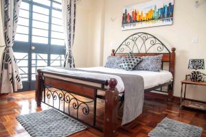 a bedroom with a large bed with a wooden floor at Westlands place 1 bedroom - Safari House, Sherry Homes in Nairobi