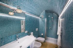 サンタニェッロにあるVilla Don Camilloの青いタイル張りのバスルーム(バスタブ、トイレ付)
