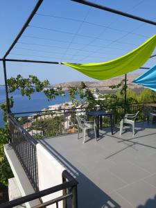 balcón con mesa, sillas y vistas al océano en Valentina Rooms en Qeparo