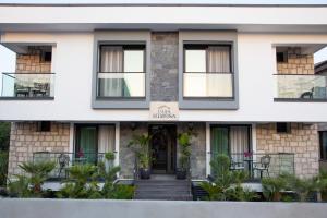 a white house with black windows at Casa Mimosa Hotel in Karaburun +11 photos