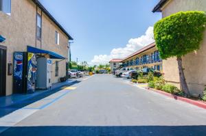 an empty street between two buildings with parked cars at Motel Moonlight in Anaheim +13 photos