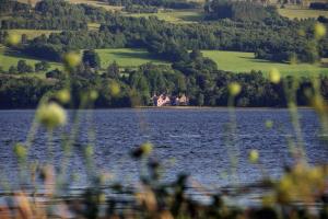 uma vista para um lago com uma casa à distância em Bunchrew House Hotel em Inverness