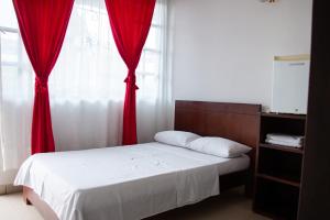 a bedroom with a bed with a red curtain and a window at Santo Domingo Centro Vacacional in Jerusalén