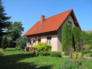 a house with a red roof and some bushes at Dom w Niechorzu in Niechorze