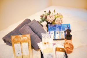 a table with a bunch of products and a vase of flowers at Hotel Plaisir Akihabara in Tokyo