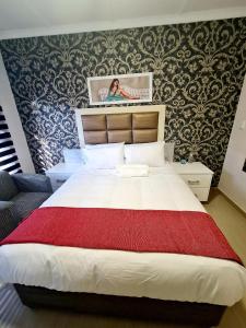 - une chambre avec un grand lit et une couverture rouge dans l'établissement 36 frere road shelly beach , margate, à Margate